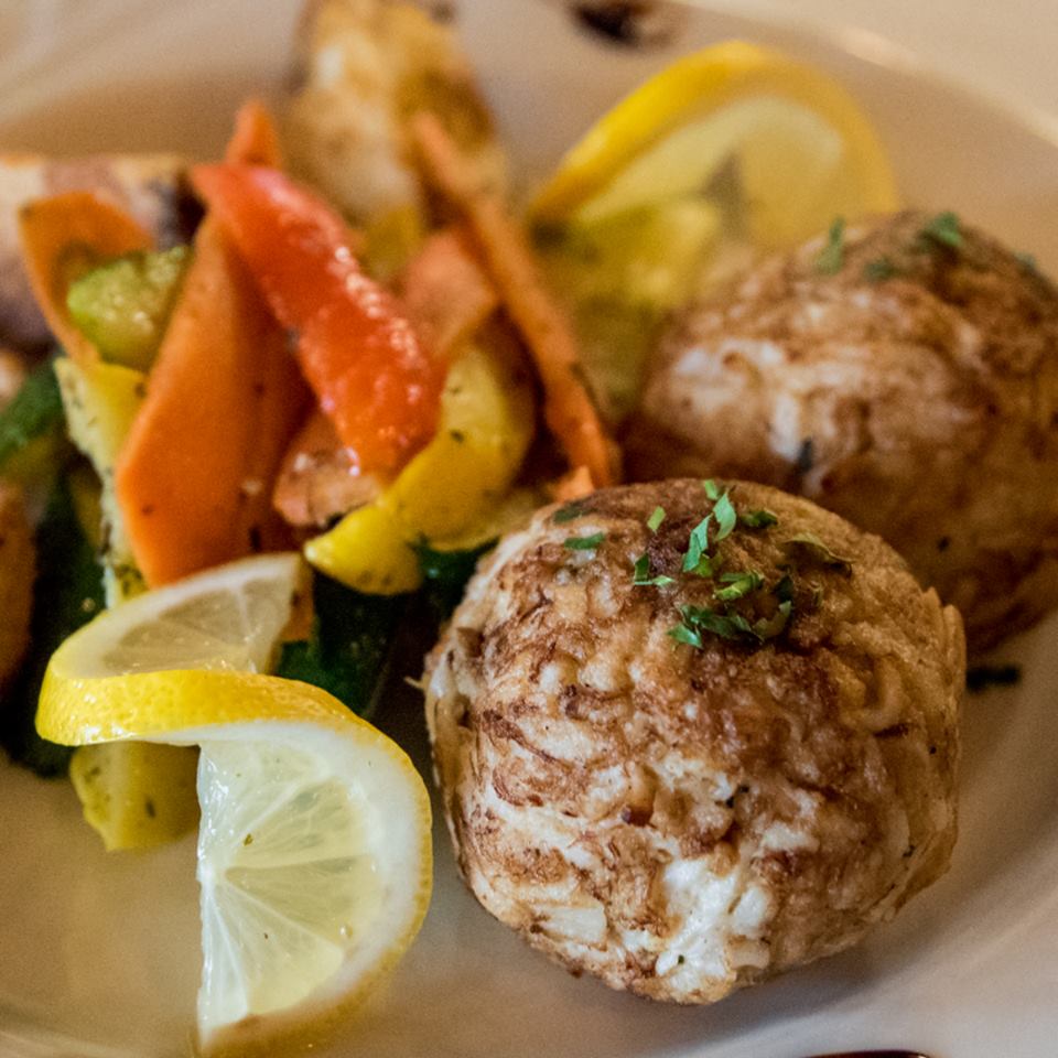 CRAB CAKES Jumbo crab cake served with a lemon butter garlic white wine saffron sauce over capellini or vegetables