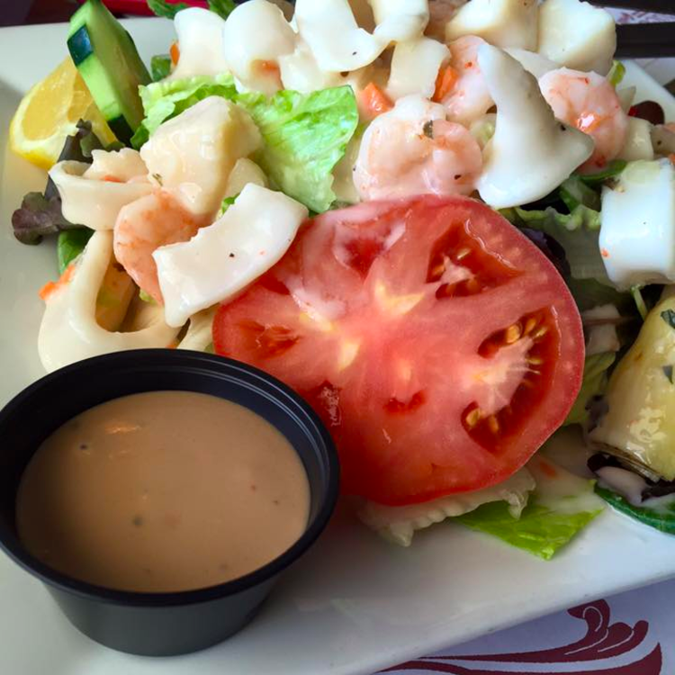 MEDITERRANEAN SALAD Marinated baby shrimp, scallops, and calamari served on top of spring mix and romaine with tomatoes, cucumbers, olives, roasted peppers, and artichokes