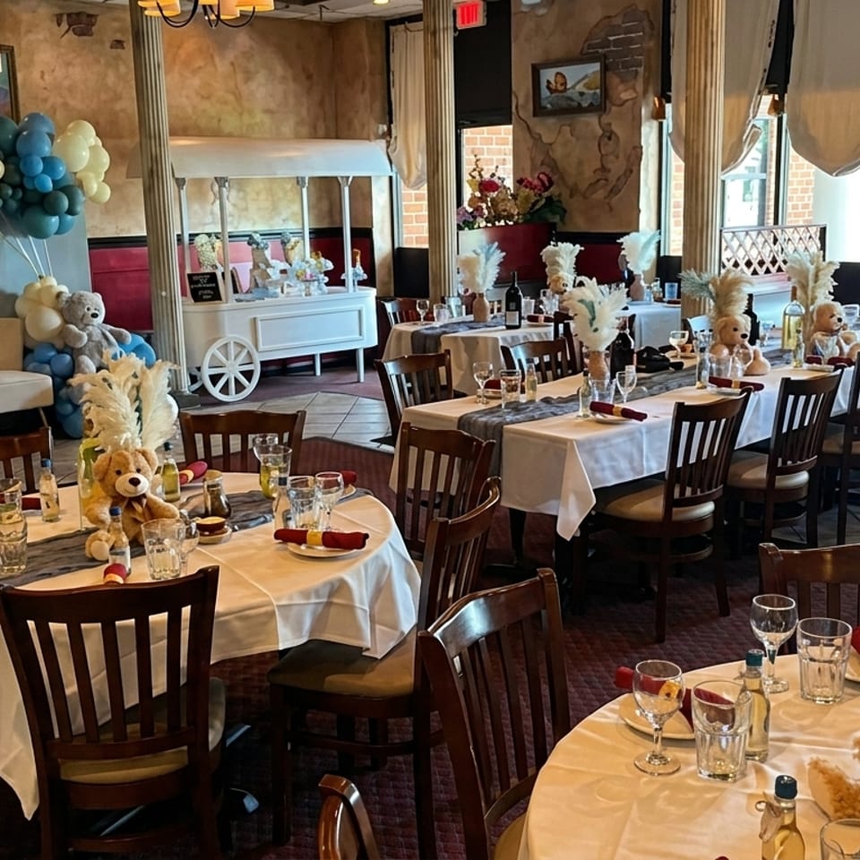 Restaurant dining room decorated for a baby shower with teddy bears, balloons, and set tables.